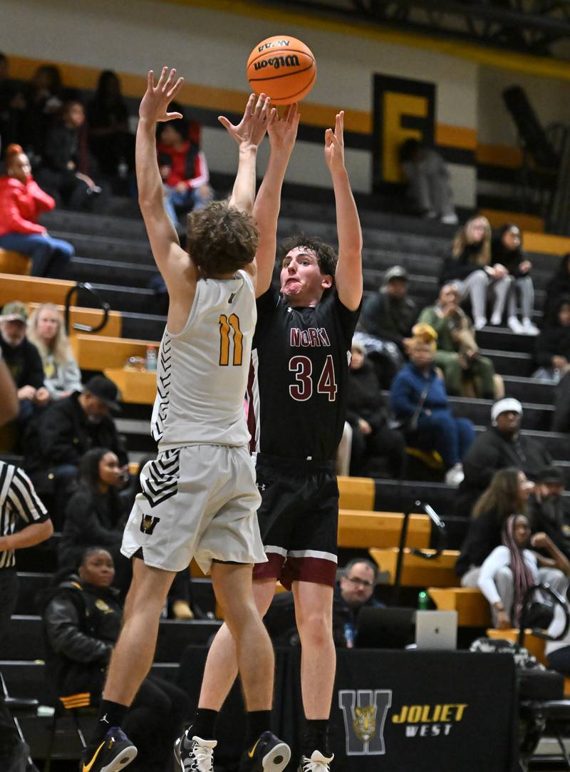 Plainfield North's Quintin Wiencek (34) shoots a 3 point shot over Joliet West's Luke Grevengoed (11) during a conference game on Friday, Dec. 20, 2024, at Joliet.