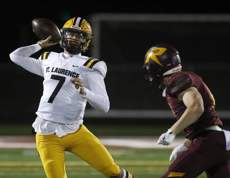 St. Laurence's Chase Kwiatkowski throws a pass as Richmond-Burton's Ryan Wisniewski classes in during an IHSA Class 4A first-round football game on Friday, Nov. 1, 2024, at Richmond-Burton High School in Richmond.