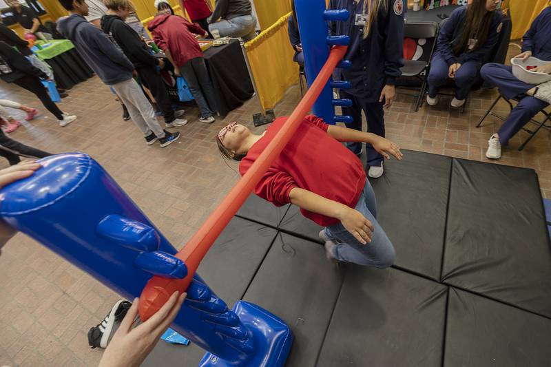 Torrie Gulke of Byron tests her agility with a limbo test at the SVCC Rad Tech booth Friday, Oct. 18, 2024, at the Pathways Playground.