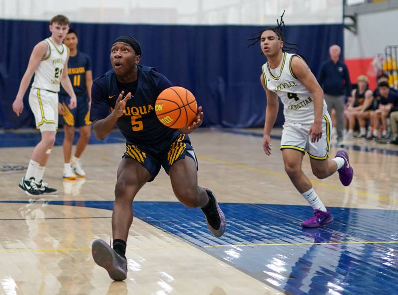 Neuqua Valley's David Taiwo (5) drives to the basket against Yorkville Christian's Tray Alford (4) during a basketball game at Yorkville Christian High School on Tuesday, February 4, 2025.