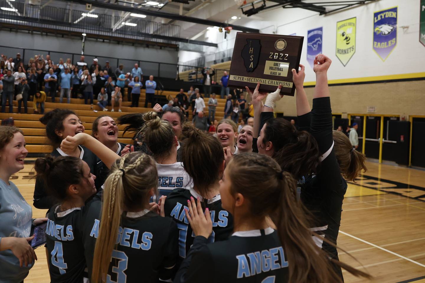 Joliet Catholic players hold up the championship plaque after their two set win over St. Laurence in the Class 3A Hinsdale South Super-sectional on Friday