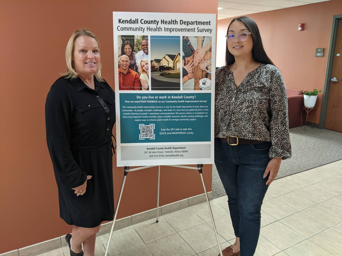 Kendall County Health Department Executive Director RaeAnn VanGundy, left, and Kendall County Health Department Assistant Executive Director Rachael Hendrickson, right, stand next to a sign about the department's community health improvement study on Friday, Sept. 19, 2025.