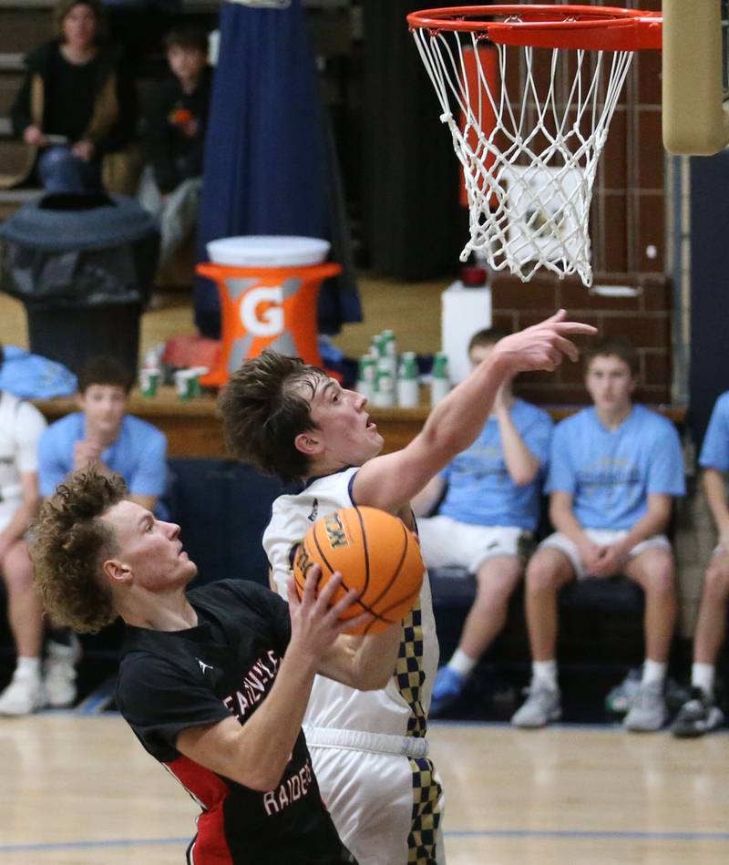 Marquette's Lucas Craig forces Earlville's Gavin Guelde to miss a shot on Friday, Jan. 3, 2025 in Bader Gym at Marquette High School.
