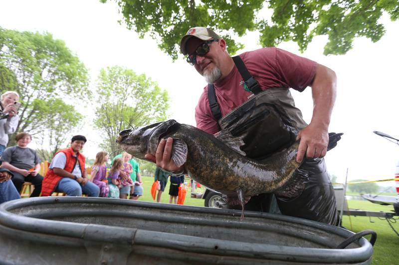 David Wyffels a fish biologist with the Illinois Department of Natural Resources holds a large flathead catfish taken from the Hennepin Canal during the twenty-third annual Kids Fishing Expo on Saturday, May 13, 2023 at Baker Lake in Peru.