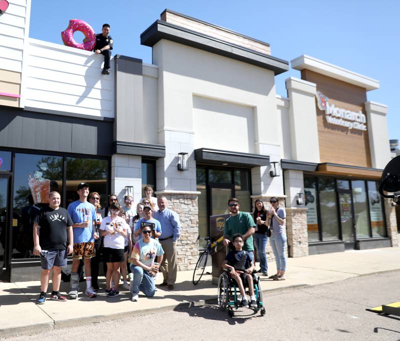 St. Charles Mayor Clint Hull (far right) joins a group of St. Charles students at the Dunkin’ Donuts on East Main Street in St. Charles on Friday, May 16. 2025 for the Cop on a Rooftop fundraiser for Special Olympics Illinois.