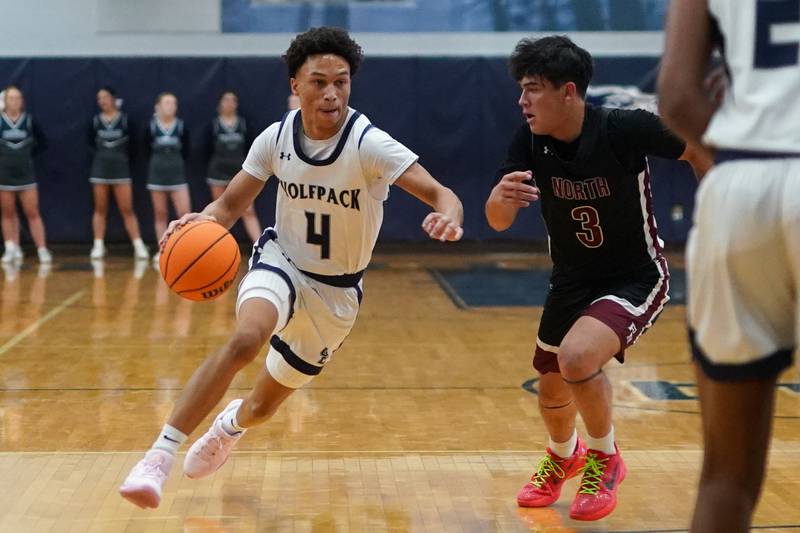 Oswego East's Myles Buchanan (4) drives to the basket against Plainfield North's Lukas Alvarez (3) during a basketball game at Oswego East High School on Friday, Dec. 6, 2024.
