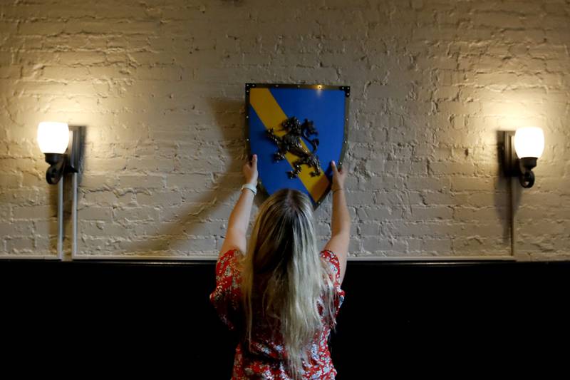 Sophia Linardos and her father, Bill, looks for places to place medieval decor on Wednesday, Sept. 11, 2024, as they prepare to open Squire on the Square restaurant in the old Public House space in the Woodstock Old Courthouse.