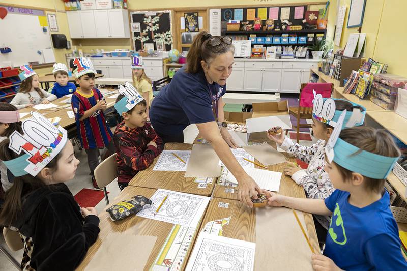 Dixon’s Jefferson School second-grade teacher Candace Buikema hands out doughnuts Thursday, Jan. 26, 2023 as a treat to her students in celebration of the 100th day of school. After the treat, the students worked on numbers problems with a 100 theme.