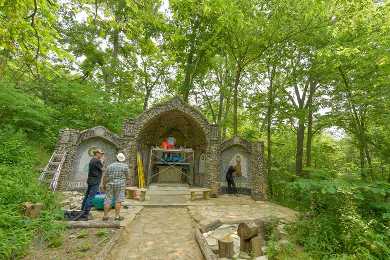 Volunteers work on restoring the Geneva Grotto, that was built by a priest in the 1930s, on Thursday, June 15, 2023.