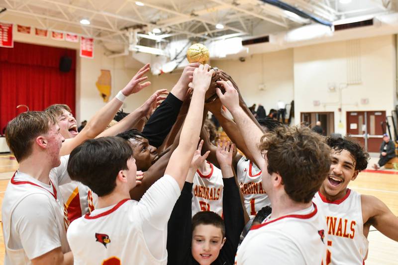 St. Anne players hoist the River Valley Conference championship trophy overhead on Friday, Feb. 14, 2025, after the Cardinals defeated Beecher 70-38 at St. Anne Community High School.