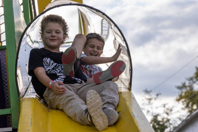 Bryant Stohr, 8, (left) slides down a carnival slide with his friend Wheyland Brewer, 8, (right) at the Tri County Fair on August 30, 2025 in Mendota.