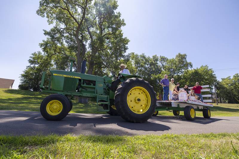 Mark Smith carries mom’s cremains and family up to the gravesite at Oakwood Cemetery Friday, July 7, 2023. Ruth Ann Pullen requested she be shuttled to her final resting place via a hayrack.