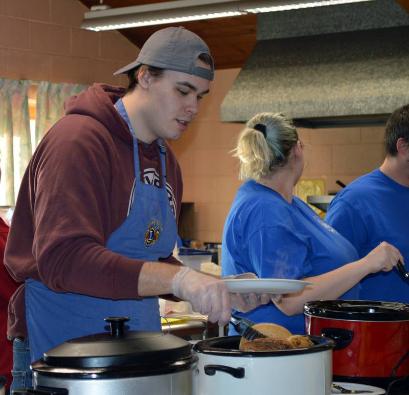 Micah Hook, of Aurora, assists in serving breakfast during the Leaf River Lion's annual Breakfast with Bunny in the Bertolet Memorial Building on April 16.