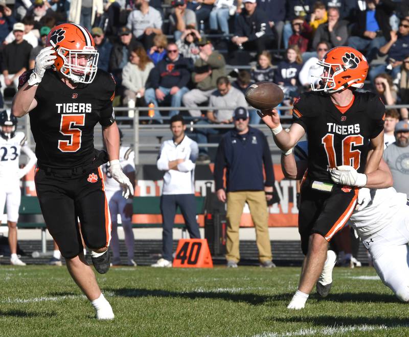 Byron quarterback Andrew Talbert (16) tries to pitch the ball to Kole Aken (5) against Elmhurst IC Catholic during 3A quarterfinals at Byron High School on Saturday, Nov. 15, 2025. The Tigers won the game 28-6 to advance to the state semifinals.