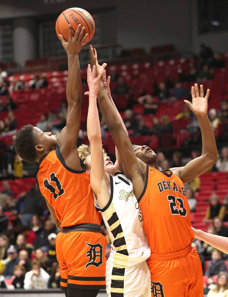 DeKalb's Jayden Wilson (left) and Davon Grant along with Sycamore's Isaiah Feuerbach go after a rebound during the First National Challenge Friday, Jan. 27, 2023, at The Convocation Center on the campus of Northern Illinois University in DeKalb.