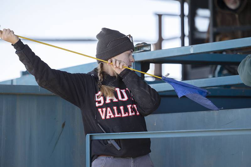Molly Duncan, a resident fellow at Nachusa, coaxes the bison through the ready chute. An elaborate set of hydraulic doors and gates directs the animals into an apparatus that applies pressure to keep them trapped and steady while the veterinarian does his work.