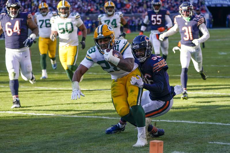 Green Bay Packers running back AJ Dillon runs for a touchdown past Chicago Bears safety DeAndre Houston-Carson during the second half, Sunday, Dec. 4, 2022, in Chicago.