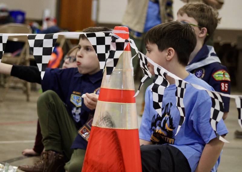 Two of the younger Cub Scouts watch with animated interest as the older members of Cub Scout Pack 85 race their pinewood derby cars on Saturday, Feb. 11, 2023, at Bethel Evangelical Congregational Church in Dixon.