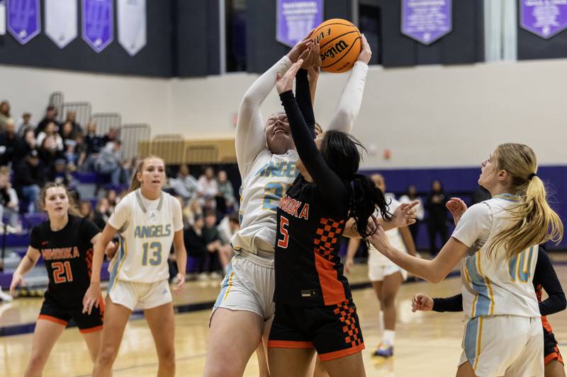 Joliet Catholic's Emma Birsa and Minooka's Summer Starks fight for a rebound during a WJOL Girls Basketball Tournament game at Joliet Junior College on Nov. 17, 2025.