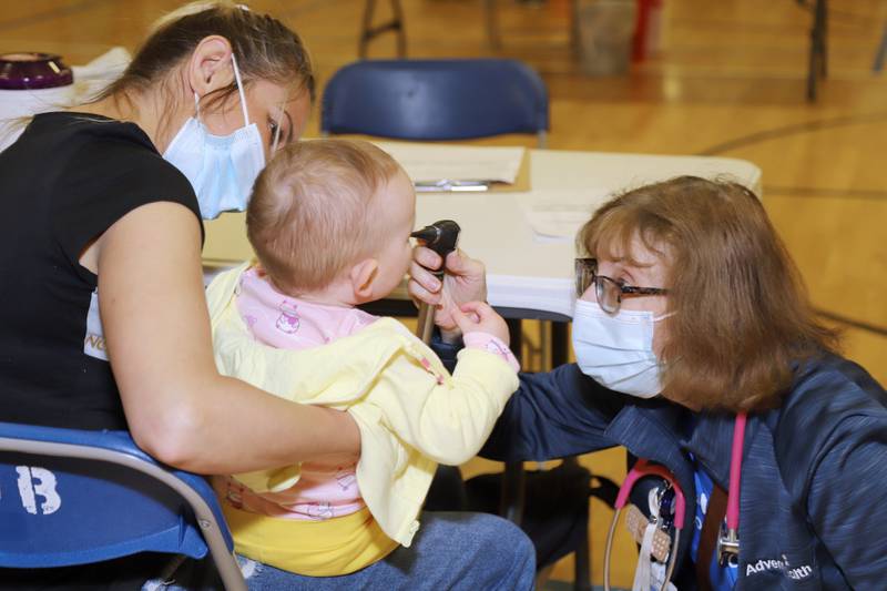 An AdventHealth clinician examines a baby at a free Mission Clinic sponsored by AdventHealth GlenOaks in Glendale Heights on June 11. AdventHealth Hinsdale and AdventHealth La Grange will sponsor a similar clinic Oct. 8 for those who cannot afford healthcare services.