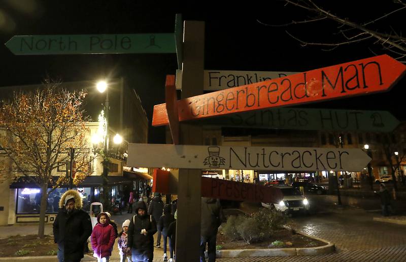 People navigate around the Woodstock Square during the Lighting of the Square Friday, Nov. 29, 2024, in Woodstock. The annual holiday season event featured brass music, caroling, free doughnuts and cider, food trucks, festive selfie stations and shopping.
