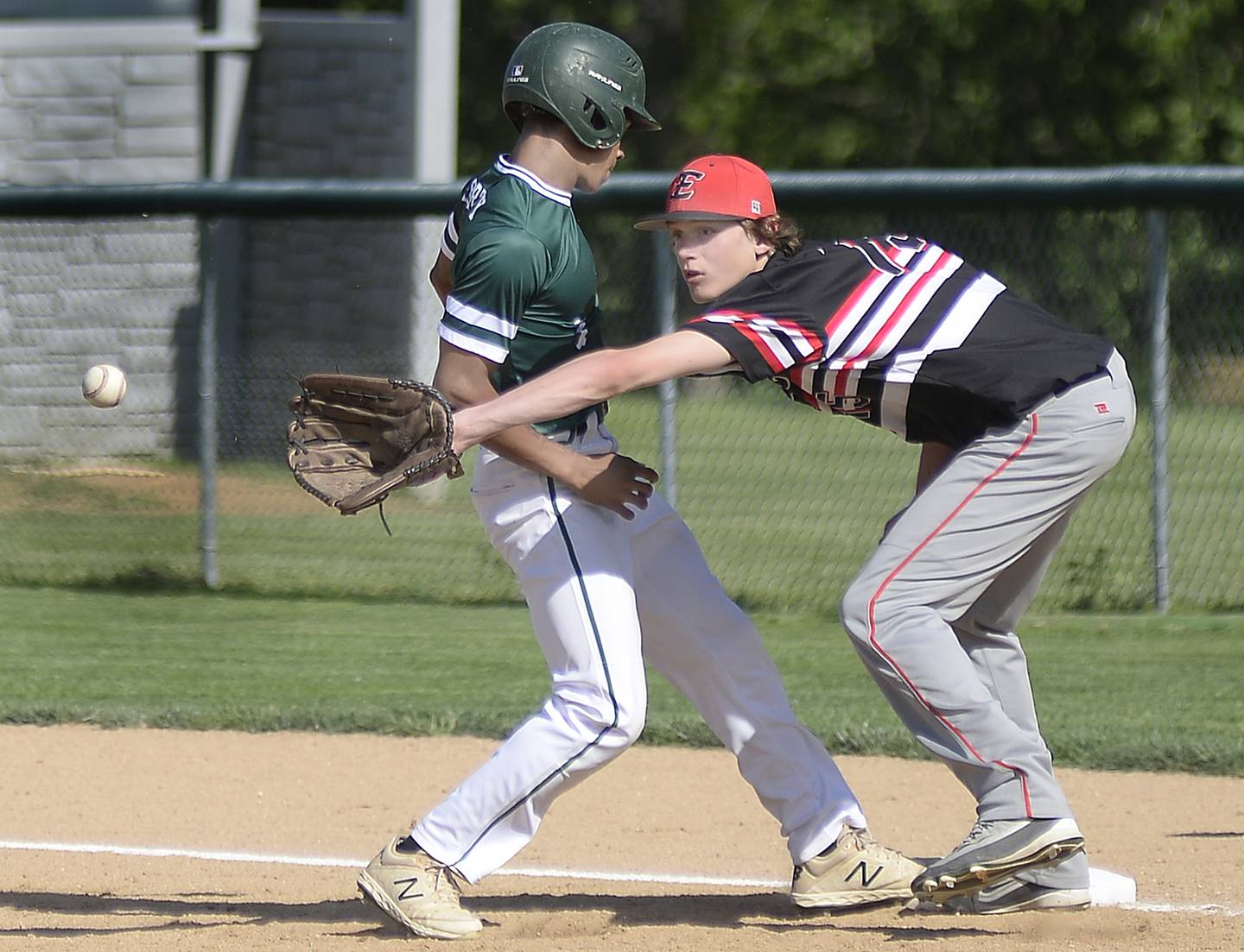 Earlville first baseman Ryan Browder reaches for a pickoff throw as St. Bede baserunner Tyreke Fortney scampers back to the bag Monday, May 16, 2022, at St. Bede Academy.