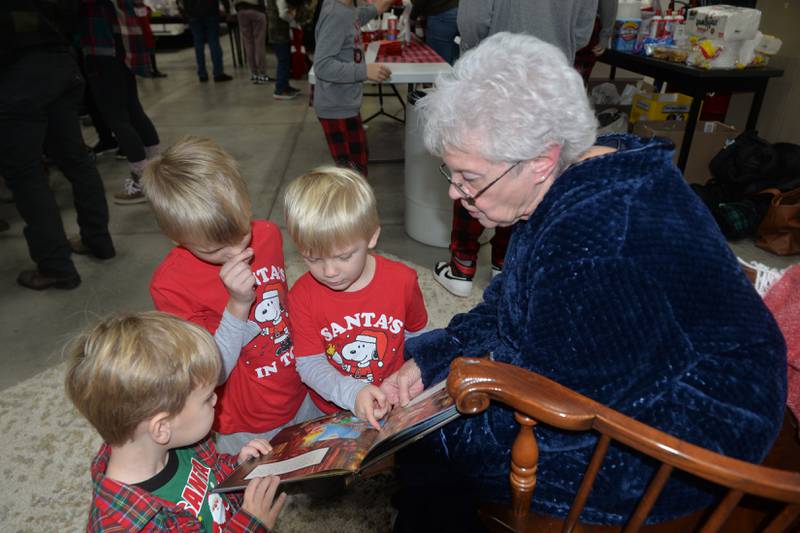 Betty Habben reads to Carl Blean 2, of Prophetstown, and Sage and Liam Heller, 4 and 6, of Genesseo during Erie's Hometown Holidays on Saturday, Dec. 2, 2023. at the Erie Fire Station. Habben's story time was one of the activities for kids.