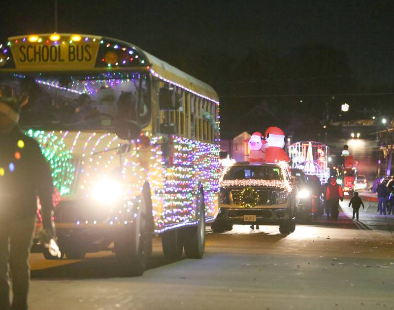 A light up school bus leads a long line of light up floats during the Light up the Night parade on Saturday, Dec. 3, 2022 downtown Peru.