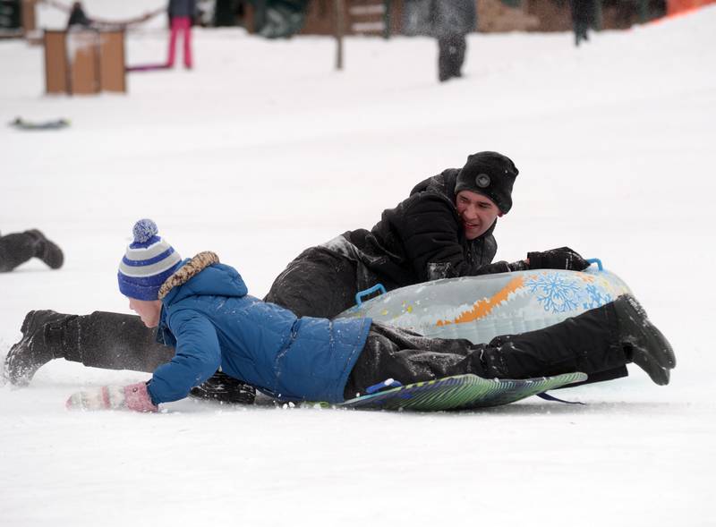 (back) Ronin Quinlan and Owen O'Mara of Wheaton fight the cold weather sledding at Northside park in Wheaton Saturday, Jan 13, 2024.