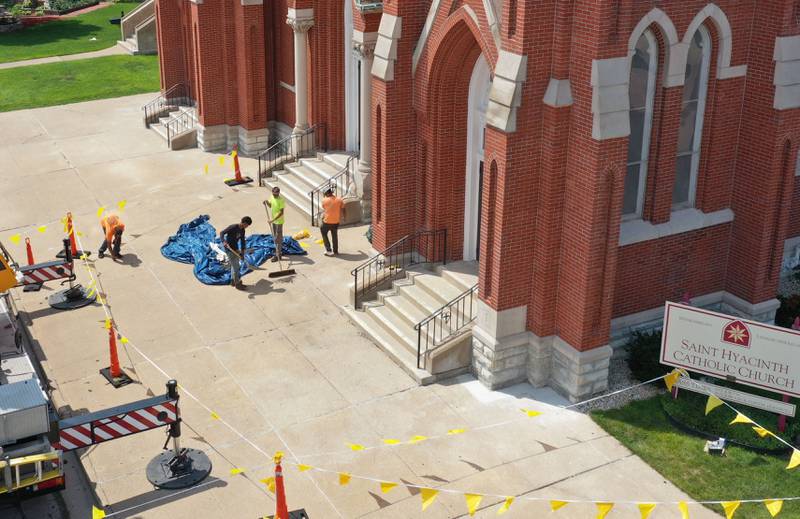 Crews work below the spires at St. Hyacinth Church on Thursday, July 25, 2024 in La Salle.