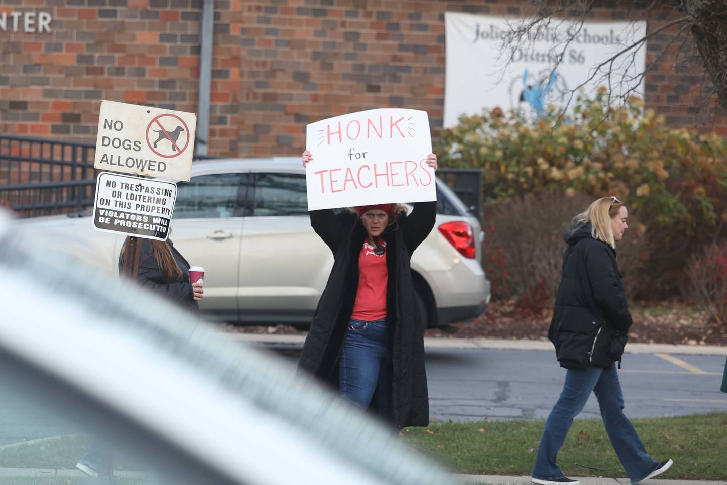 A teacher holds a sign for passing cars to show support by honking for teachers outside District 86 Administrative Center on Monday in Joliet. District 86 teachers are currently working with a contract.