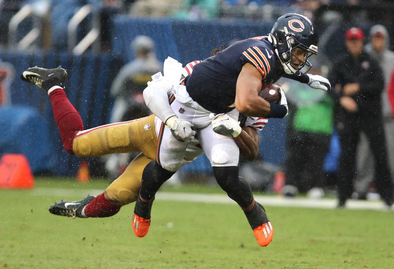 Chicago Bears quarterback Justin Fields is brought down by San Francisco 49ers linebacker Fred Warner after scrambling for yardage during their game Sunday, Sept. 11, 2022, at Soldier Field in Chicago.