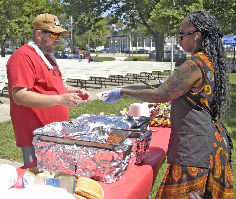 Brandon Gear of Rock Falls buys a brat from Tierra Crowder at the Juneteenth celebration. . The Sauk Valley Diversity Alliance hosted a Juneteenth  Event on Saturday, June 21st, 2025 at the Grandon Civic Center in Sterling.