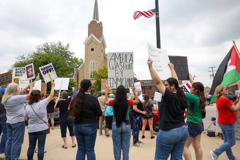 Protesters hold signs on the topic of immigration as approximately 500 people gathered at the Kankakee County Courthouse for a ‘No Kings’ rally in Kankakee on Saturday, June 14, 2025, to protest actions by President Donald Trump.