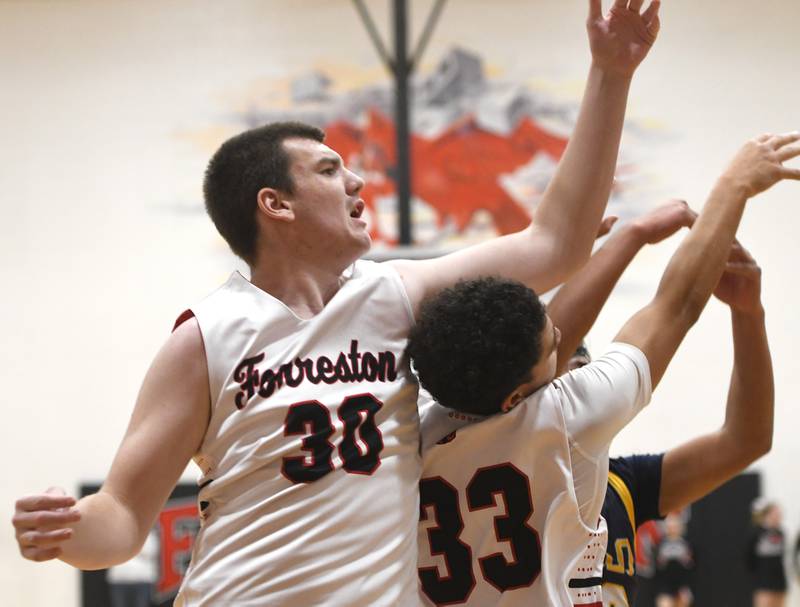Forreston's Owen Williams (30) and Dyalen Rahn reach for a rebound against Polo  on Saturday, Dec. 13, 2025 at the 64th Annual Forreston Holiday Basketball Tournament held at Forreston High School.