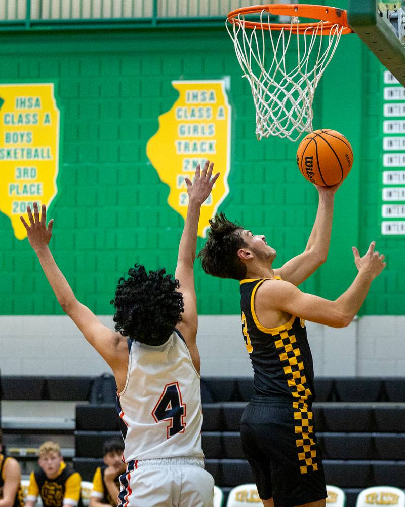 Jesse Tresouthick (3) of Reed-Custer lays ball up whilst Diego Perez (4) of DePue jumps to contest shot during game in the Shipyard Showdown on Tuesday, December 23, 2025 at Seneca High School in Seneca.