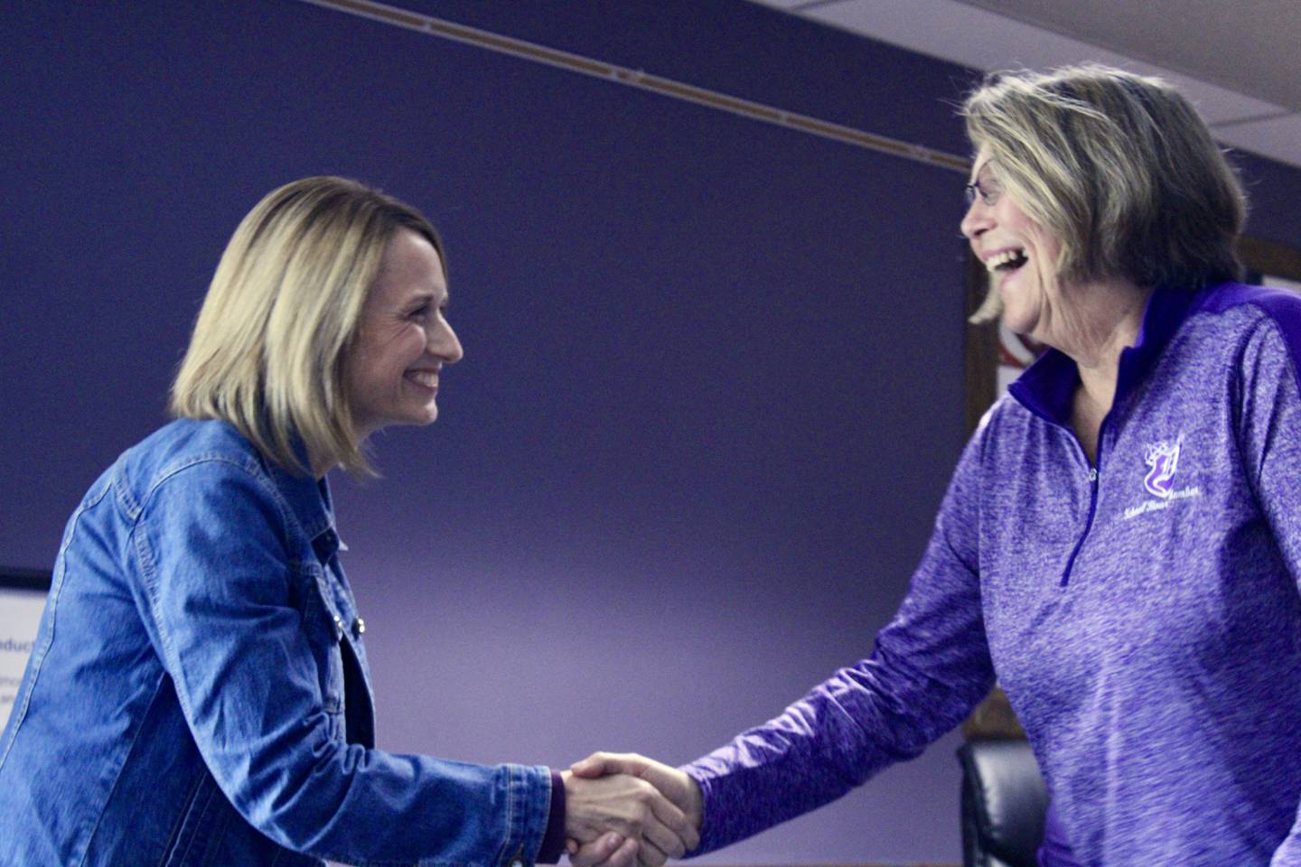 Kathleen Schaefer accepts a handshake from Dixon Public Schools board President Linda Wegner after being inducted to the board of education to fill an unexpired term on Wednesday.