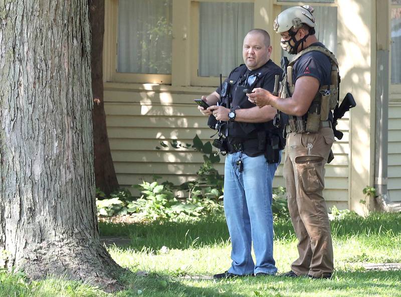 Law enforcement officers from several agencies try to coax a man down from the roof of a home in the 1400 block of Clark Street Thursday, Sept. 8, 2022, in DeKalb.
