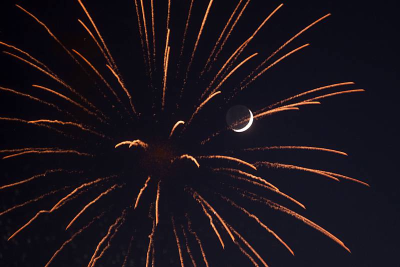 A sliver of a moon shines through the colorful explosions of the Jaycees fireworks show Friday over Sterling and Rock Falls.