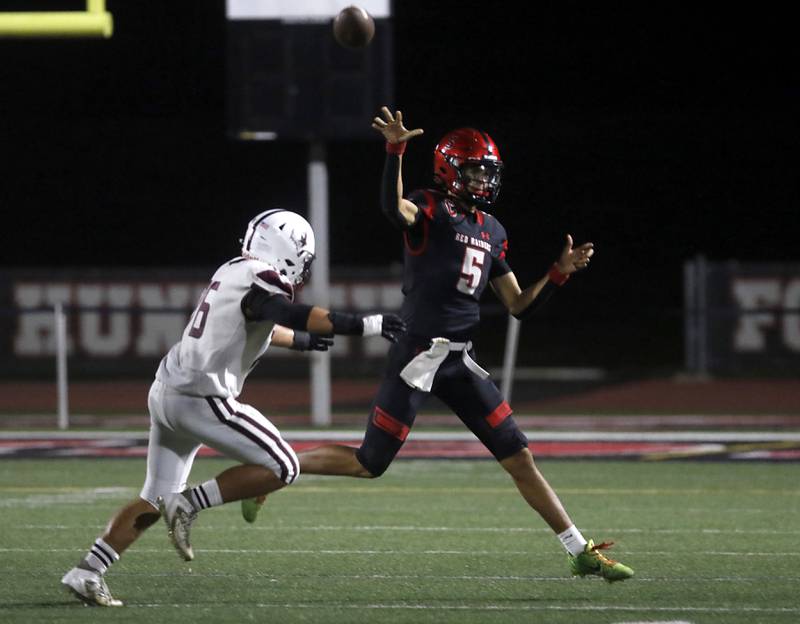 Huntley's Malik Carter throws the ball as Prairie Ridge's Trenton Horton chases him during a Fox Valley Conference football game on Friday, Oct. 3, 2025, at Huntley High School.