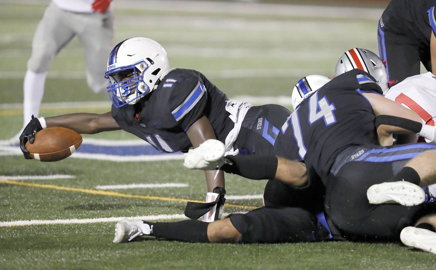 St. Charles North's Joell Holloman (11) dives for some extra yards Friday August 25, 2023 in St. Charles.