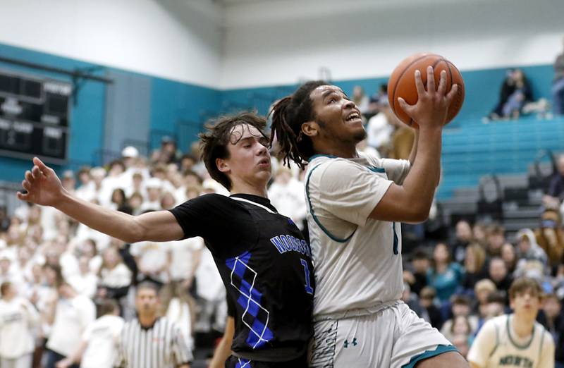 Woodstock North's Elijah White drives to the basket against Woodstock's Collin Greenlee during a Kishwaukee River Conference boys basketball game on Friday, Jan. 5. 2024, at Woodstock North High School.