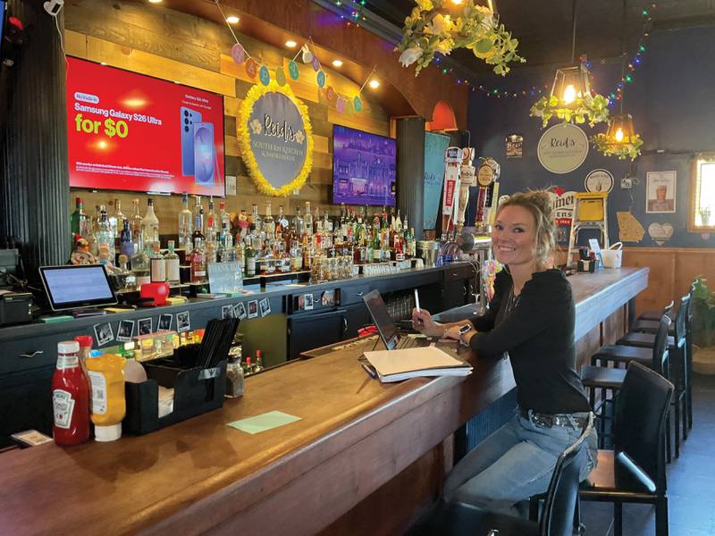 Amanda Racz, owner of Reid's Southern Kitchen and Smokehouse, sits at the vintage bar of her Peru restaurant in April 2026. Racz grew up in Georgia, which influenced many of the menu options at Reid's.
