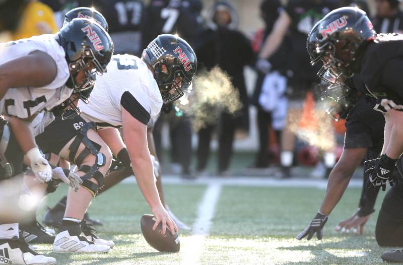 Northern Illinois University offensive and defensive linemen line up for a play on a chilly morning during spring practice Friday, April 7, 2023, in Huskie Stadium at NIU in DeKalb.