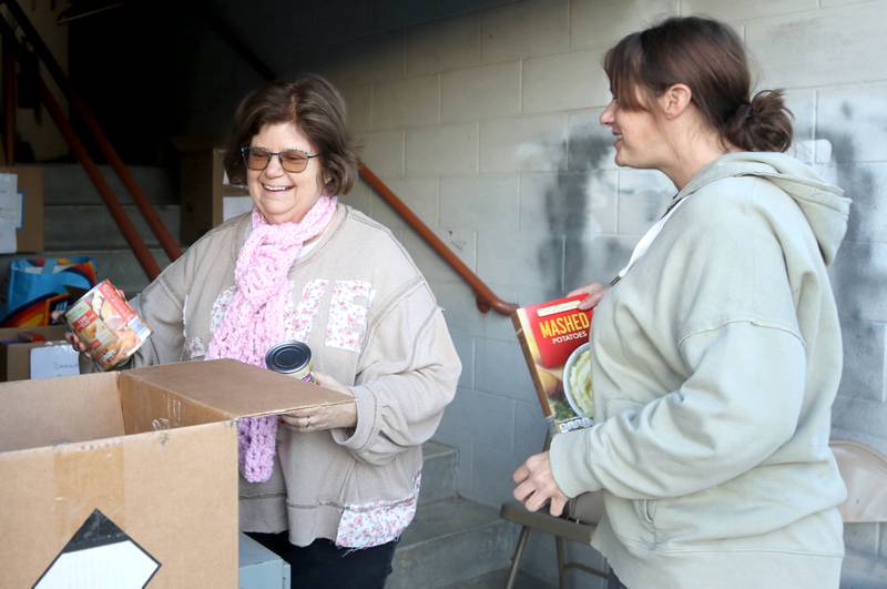 Donna O’Hagan, (left) a Stage Coach Players member, and Angela Schiola, Stage Coach Players community outreach chair, sort donated food into boxes Tuesday, Nov. 12, 2024, at the Stage Coach Theatre in Dekalb. The food collected will be assembled into dinner boxes to provide local families with a Thanksgiving meal.