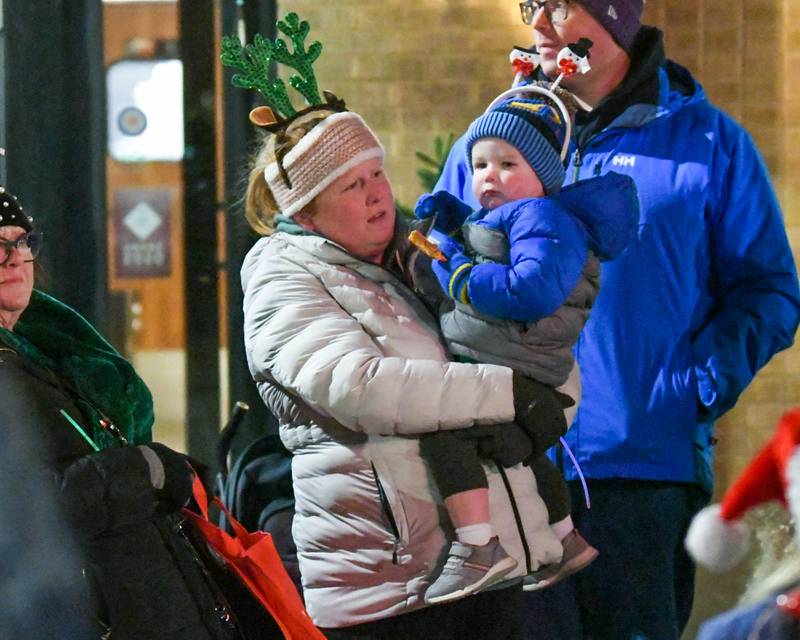 Nicole Rakers and her 2 year old son Emmett Kane of Wheaton watch the holiday parade in downtown Wheaton on Friday Nov. 24, 2023.
