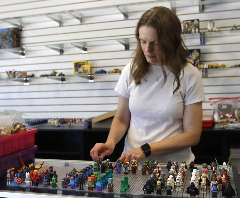 Julie Krater sorts a minifigs on Thursday, June 13, 2024, at she helps prepare the Bricks and Minifigs store to opening in Algonquin.
