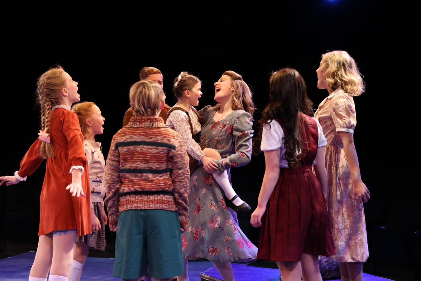 Maria (Cassidy Hamilton of New York, center) holds Gretl (Ava Doty of Downers Grove) in "The Sound of Music" production.
