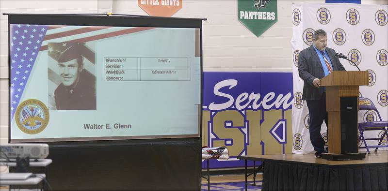 As a slide show plays showing local veterans, Superintendent Rich Faivre welcomes the audience to a Veterans Recognition Ceremony Tuesday  at Serena High School.