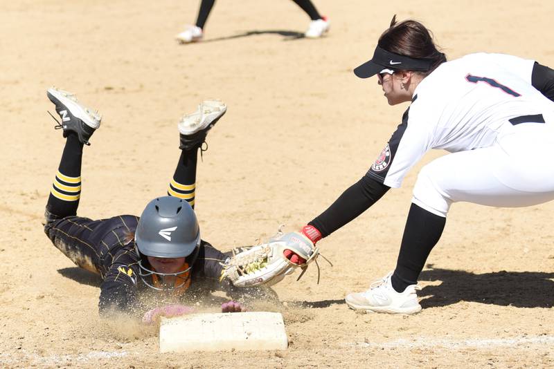 Herscher's Audrey Hoffman, left, dives into third base ahead of a tag from Bradley-Bourbonnais' Tristin Woods during a game at Bradley-Bourbonnais Monday, March 24, 2025.